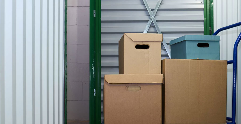 Cartons de déménagement de différentes tailles disposés avec un mètre ruban montrant leurs dimensions standards